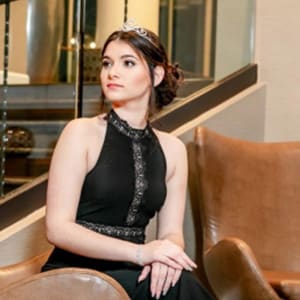Claudia sitting with arms folded in lap